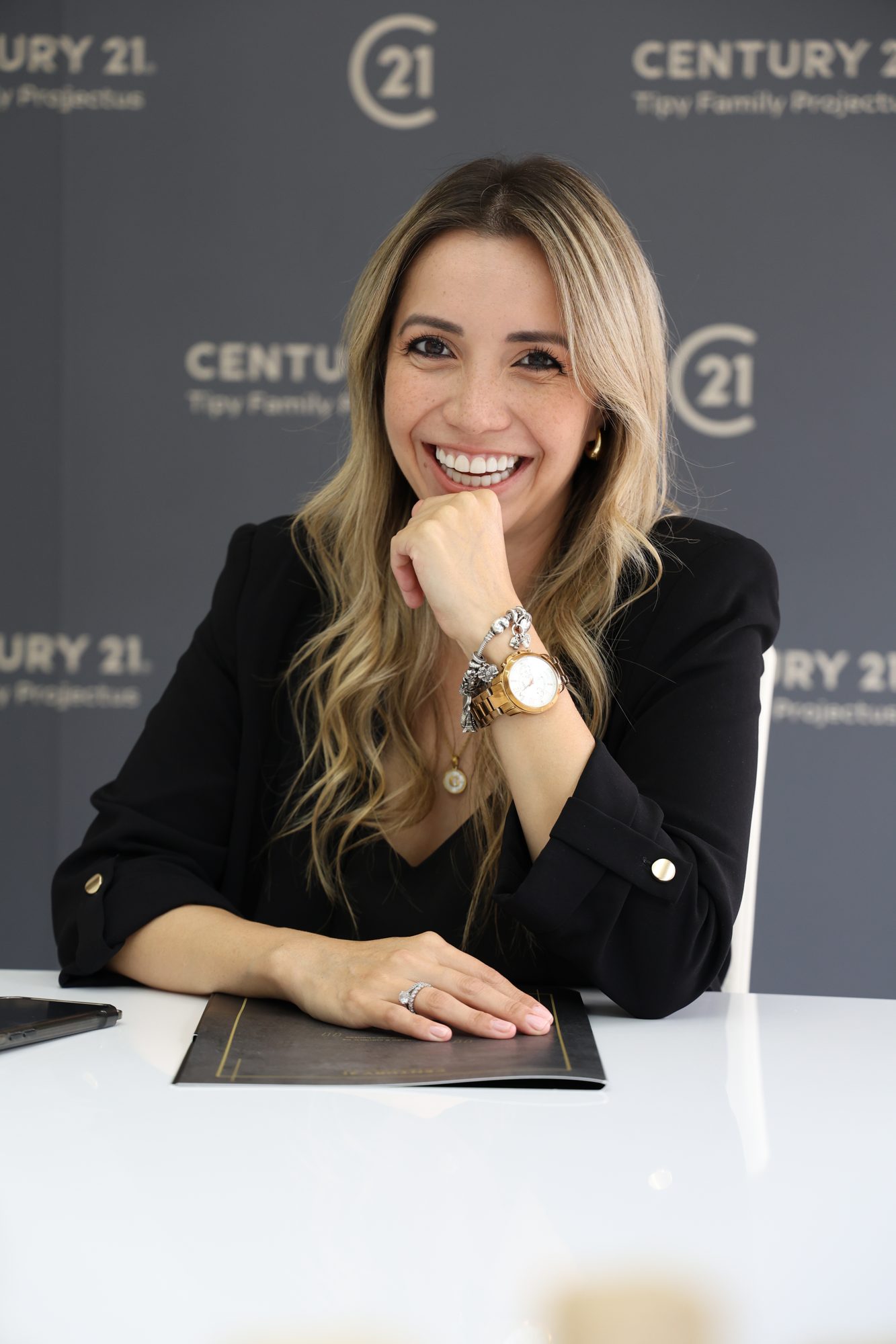 Retrato de consultora imobiliária sentada a uma secretária, com pasta corporativa, fotografia de Daniel Robles