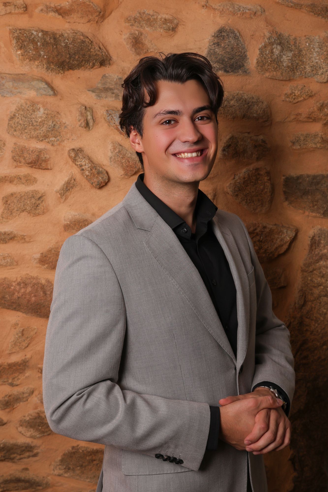 Retrato profissional de jovem empresário de blazer cinzento-claro, junto a parede de pedra, fotografia de Daniel Robles